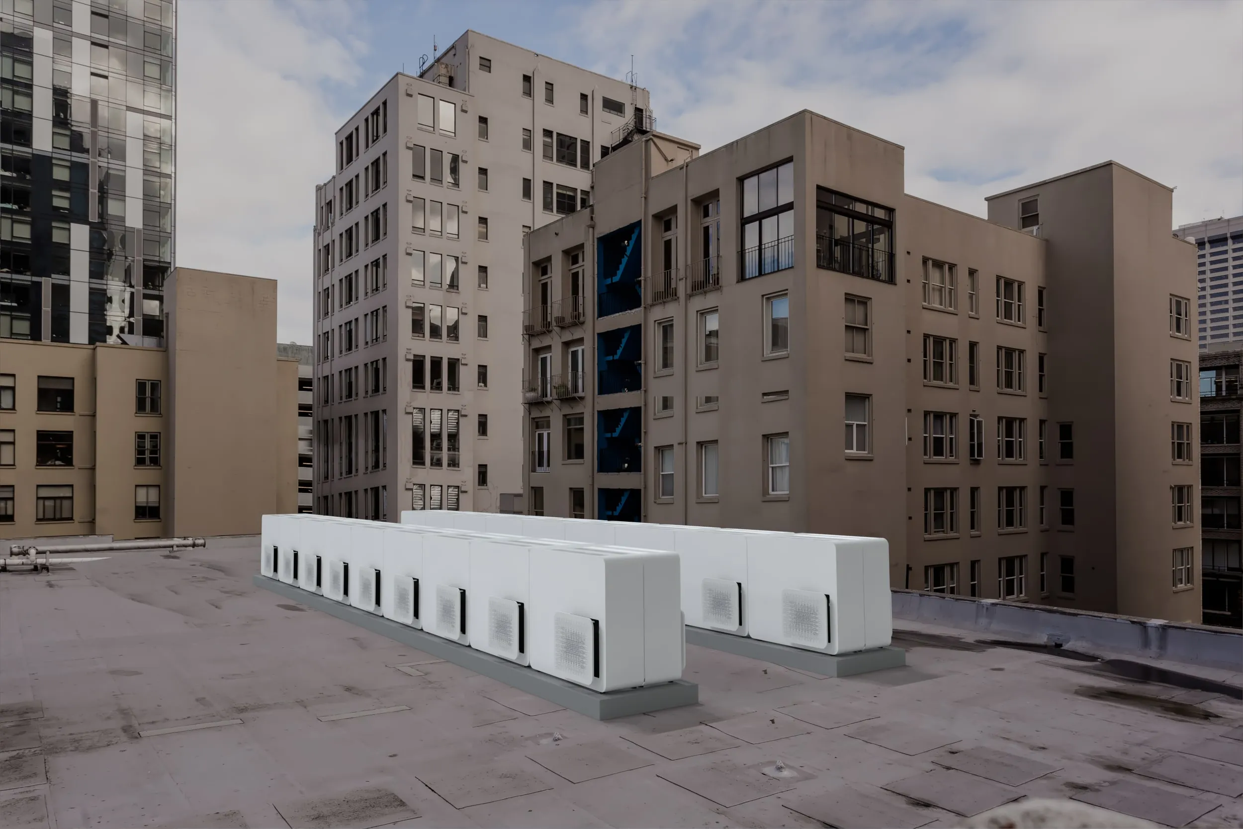 A row of STØNE outdoor units on an apartment-building roof terrace