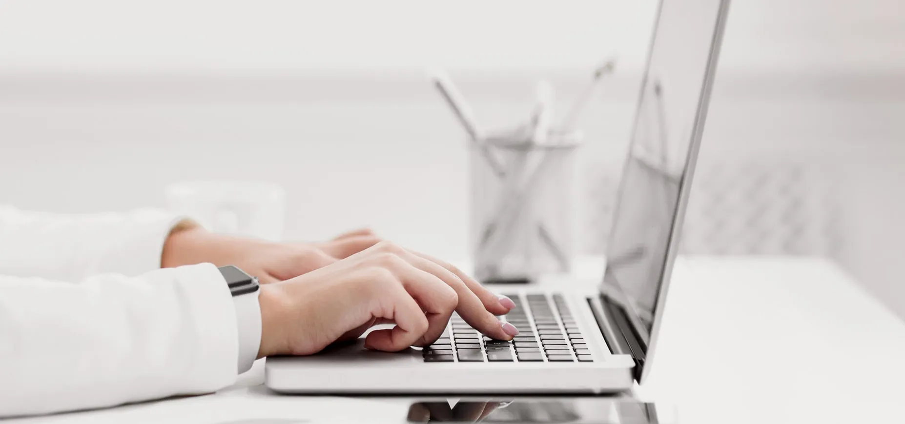 Hands typing on a laptop keyboard